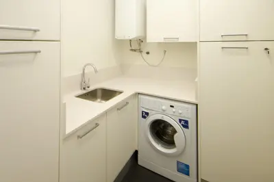 a white kitchen with a washing machine and a sink at Total Valencia Elegance in Valencia