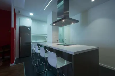 a kitchen with a bar with stools and a counter top at Total Valencia Elegance in Valencia