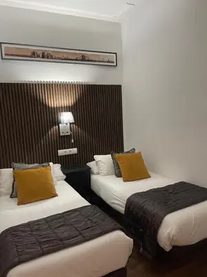 two beds in a hotel room with yellow pillows at Total Valencia Elegance in Valencia
