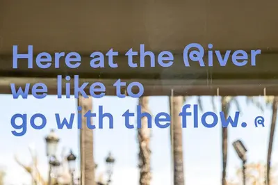 a white building with palm trees in front of it at River Hostel in Valencia