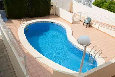a swimming pool on a patio with a table and a chair at SingularStays Puzol Beach VII in Puzol