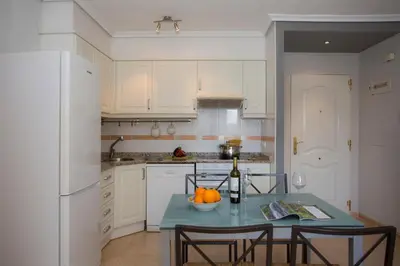 a kitchen with a table with a bowl of fruit on it at SingularStays Puzol Beach VII in Puzol