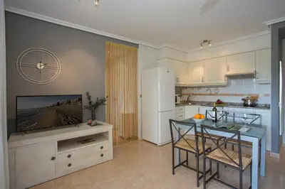 a kitchen with a table and a white refrigerator at SingularStays Puzol Beach VII in Puzol