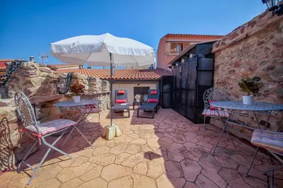 a patio with tables and chairs and an umbrella at Valterra y Tosal in Torres-Torres