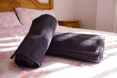 a black towel sitting on top of a bed at APARTAMENTO LOS NARCISOS in Chulilla