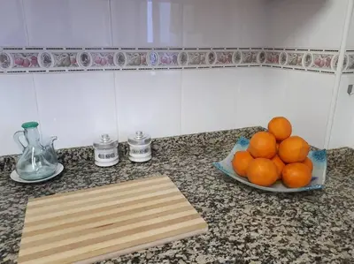a bowl of oranges on a counter with a plate of fruit at APARTAMENTO LOS NARCISOS in Chulilla