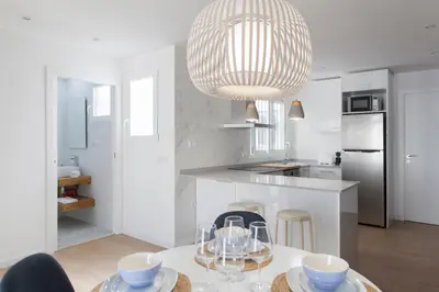 a white kitchen with a table and a chandelier at FLORIT FLATS - Apartment Torres de Quart II in Valencia
