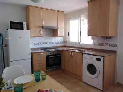 a kitchen with a white refrigerator and a dishwasher at El apartamento de Marina en Chilches playa in Xilxes