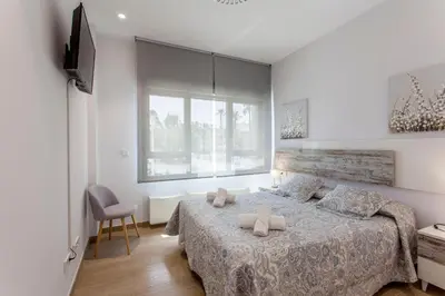 a bedroom with a large bed and a window at ApartUP Patacona Select in Valencia