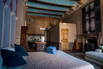 a bedroom with a large bed with blue pillows at DOMUS Amabilis in Sagunto