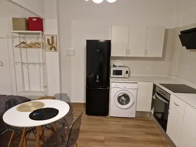 a kitchen with a black refrigerator and a table with chairs at Style Apartments Cabanyal Marina Beach in Valencia