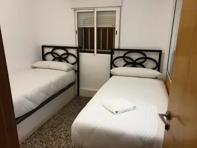 two beds in a small room with white sheets at Style Apartments Cabanyal Marina Beach in Valencia