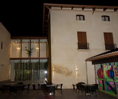 a group of tables and chairs in front of a building at Hotel-Restaurante Casa Blava Alzira in Alzira