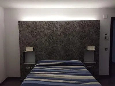 a bedroom with a bed and a wall at Hotel-Restaurante Casa Blava Alzira in Alzira