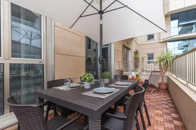 a table with chairs and an umbrella on a balcony at PATACONA BEACH VISTAS AL MAR in Valencia
