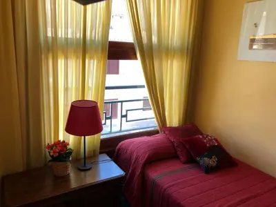 a bedroom with a bed with a lamp and a window at Casa Rural 