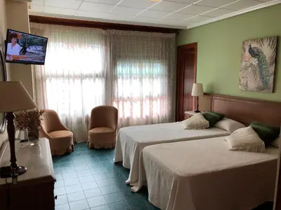 a hotel room with two beds and a flat screen tv at Casa Rural 