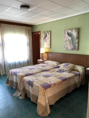 a bedroom with two beds and a window at Casa Rural 