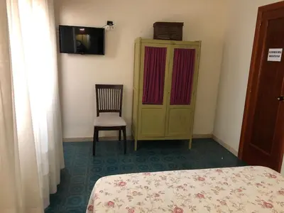 a bedroom with a bed and a chair and a cabinet at Casa Rural 