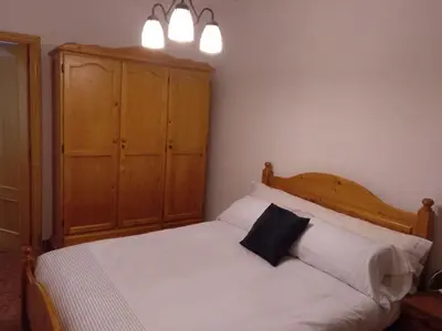 a bedroom with a white bed with a wooden headboard at Casa Vall de Almonacid in Vall de Almonacid