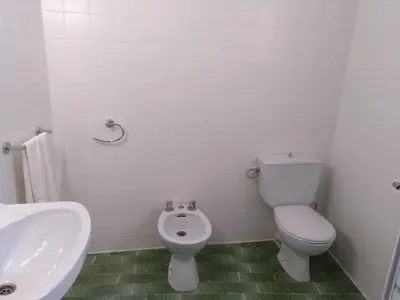 a white bathroom with a toilet and a sink at Casa Vall de Almonacid in Vall de Almonacid