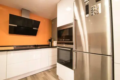 a kitchen with a stainless steel refrigerator and a tv at Céntrico y reformado con estilo in Valencia