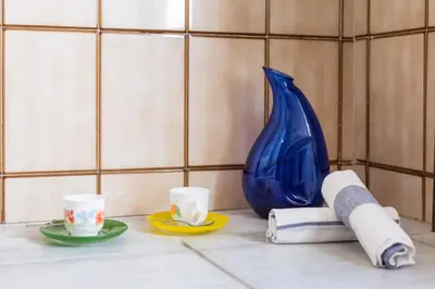 a table with two cups and a blue vase at Casa Valle del Turia in Chulilla