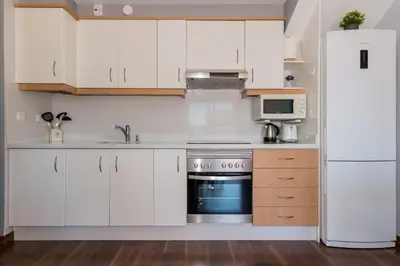 a kitchen with white cabinets and a refrigerator at Duplex Penthouse with terrace. Beach-Pool in Canet de Berenguer