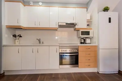 a kitchen with white cabinets and a refrigerator at Duplex Penthouse with terrace. Beach-Pool in Canet de Berenguer