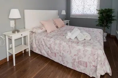 a bedroom with a bed with a pink comforter and pillows at Duplex Penthouse with terrace. Beach-Pool in Canet de Berenguer