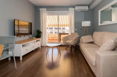 a living room with a couch and a television at Duplex Penthouse with terrace. Beach-Pool in Canet de Berenguer