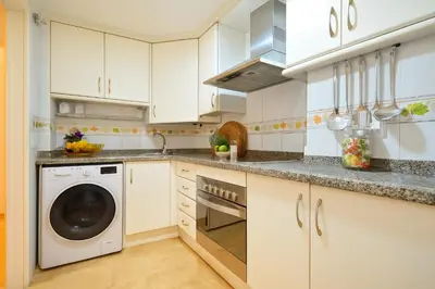 a kitchen with white cabinets and a dishwasher at City Center Apartment in Valencia