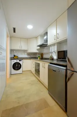 a kitchen with white cabinets and stainless steel appliances at City Center Apartment in Valencia