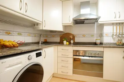 a kitchen with white cabinets and a dishwasher at City Center Apartment in Valencia