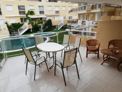 a patio with a table and chairs on a balcony at Parquemar VIII Solo Familias Serviplaya in Playa de Xeraco