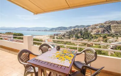 a table and chairs on a balcony with a view of the water at 2 Bedroom Cozy Home In Faro De Cullera in Faro de Cullera
