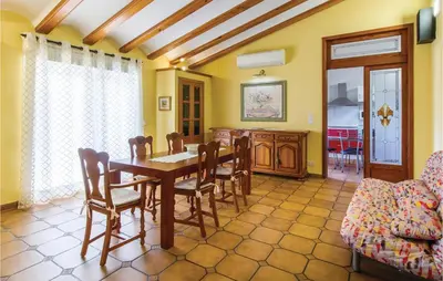 a dining room with a wooden table and chairs at 2 Bedroom Cozy Home In Faro De Cullera in Faro de Cullera