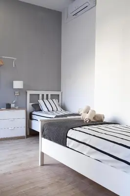 two beds in a bedroom with a teddy bear on the bed at Plaza Redonda Center in Valencia