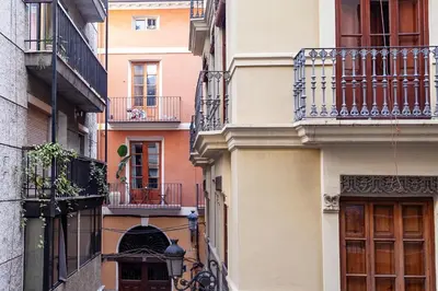 an alley between two buildings with balconies at Plaza Redonda Center in Valencia