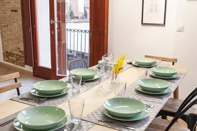 a table with green plates and glasses on it at Plaza Redonda Center in Valencia