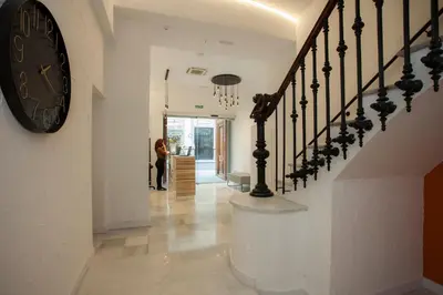 a woman walking down a hallway with a clock on the wall at Casual Socarrat Valencia - Adults Only in Valencia