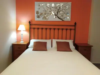 a bedroom with a large bed with orange walls at PATACONA MARE NOSTRUM APARTMENT II in Valencia