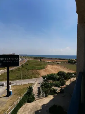 a sign on a building with the ocean in the background at PATACONA MARE NOSTRUM APARTMENT II in Valencia