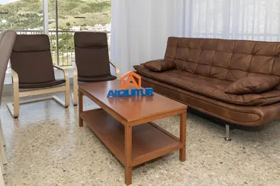 a living room with a couch and a table and chairs at AGUAMARINA C, 11-51 in Cullera