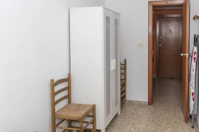 a room with a door and a chair next to a wall at AGUAMARINA C, 11-51 in Cullera