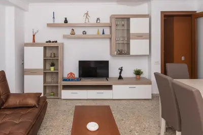 a living room with a couch and a television at AGUAMARINA C, 11-51 in Cullera
