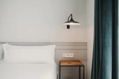 a bedroom with a bed and a table with a lamp at Room Mate Collection Helen Berger in Valencia