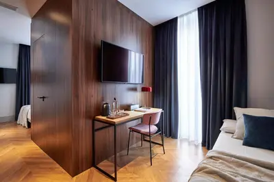 a hotel room with a desk with a tv on a wall at Room Mate Collection Helen Berger in Valencia