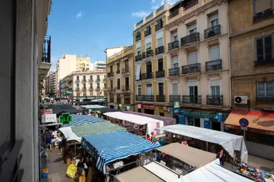 a city street filled with stalls with people and buildings at SingularStays Valencia Center in Valencia