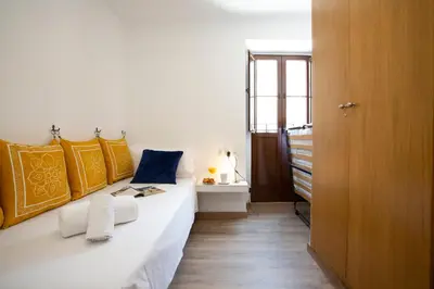 a bedroom with a white bed with yellow and blue pillows at SingularStays Valencia Center in Valencia